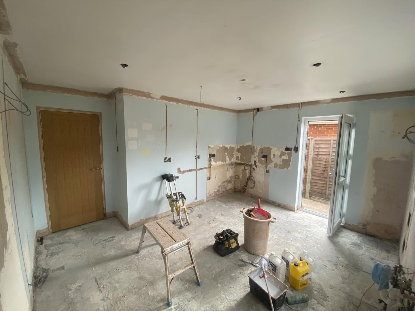 A room stripped back, with old pale blue walls patched