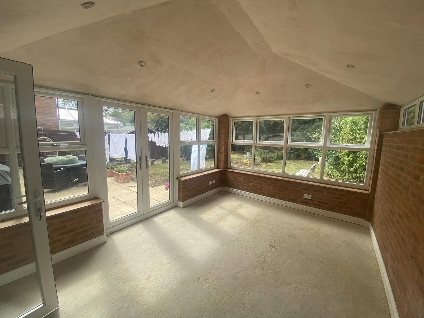 The finished garden room: vaulted ceiling, brick wall and French doors