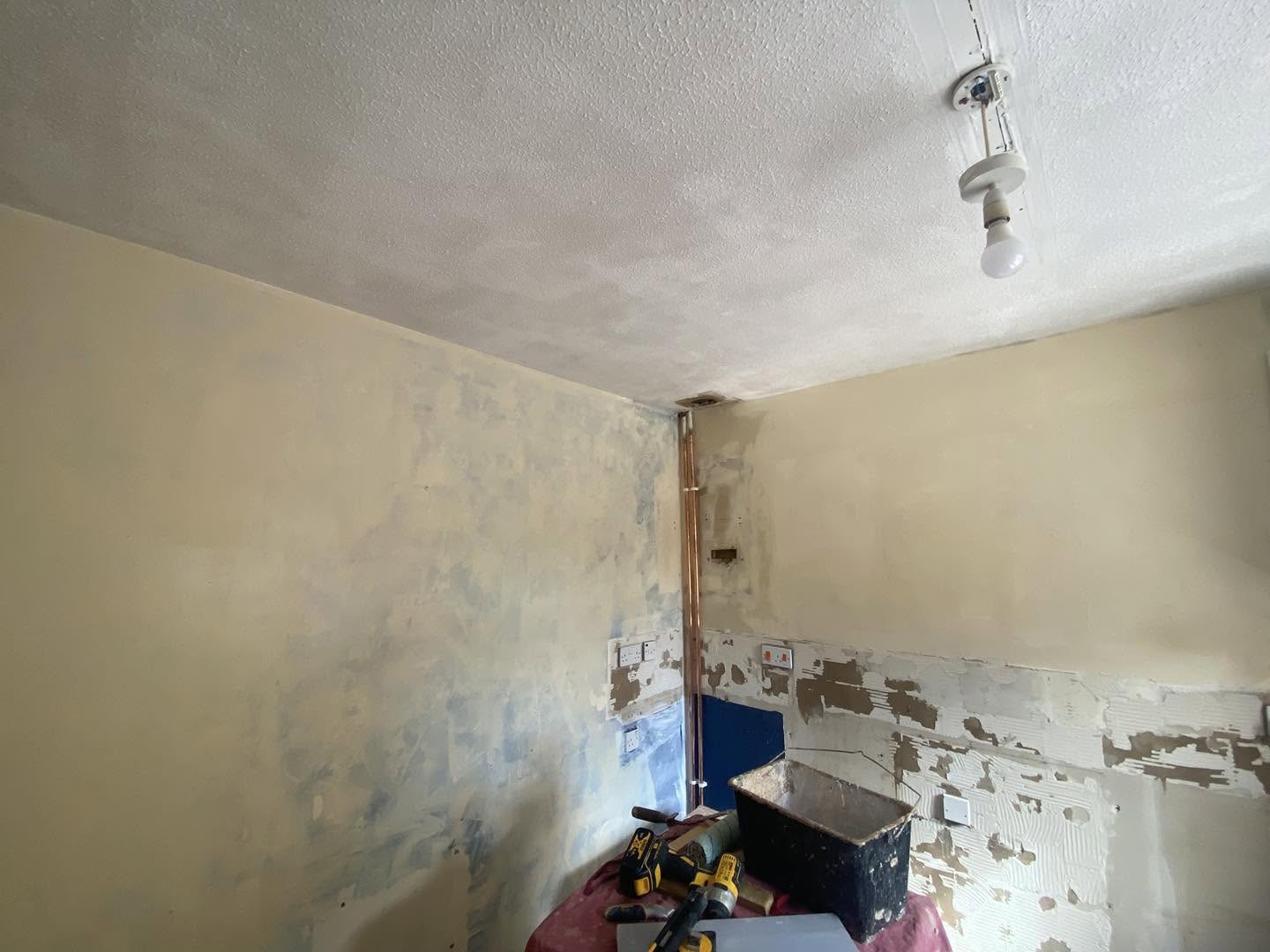 Kitchen walls stripped, with marks where old tiles came off