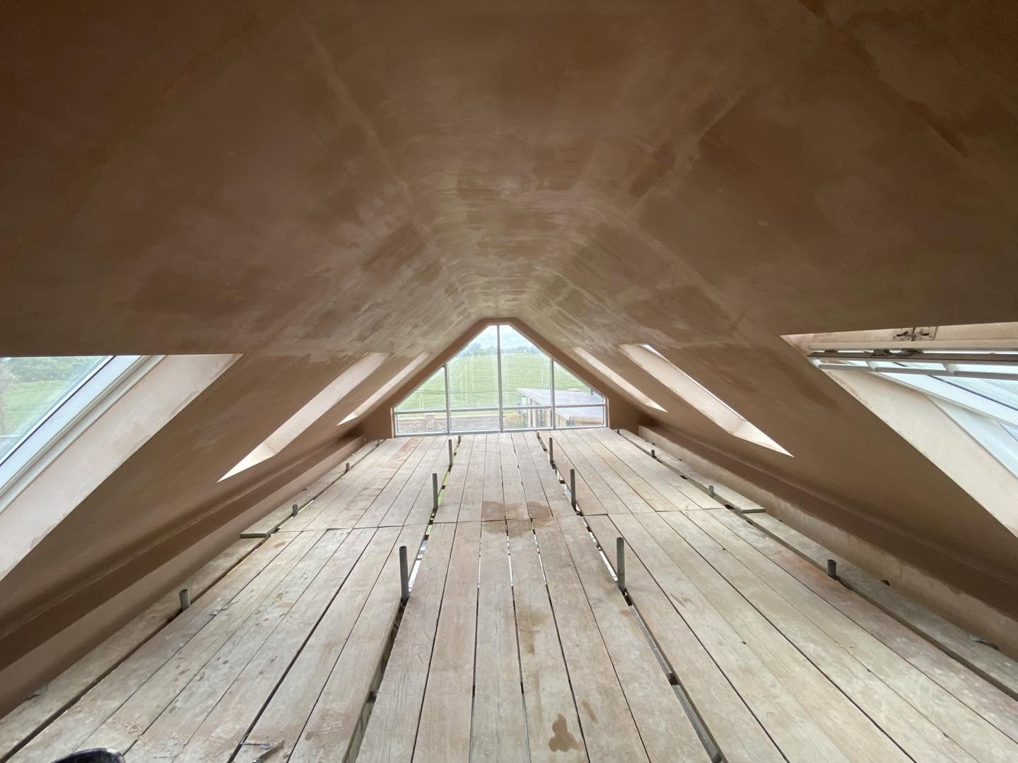 A loft ceiling freshly skimmed between roof windows