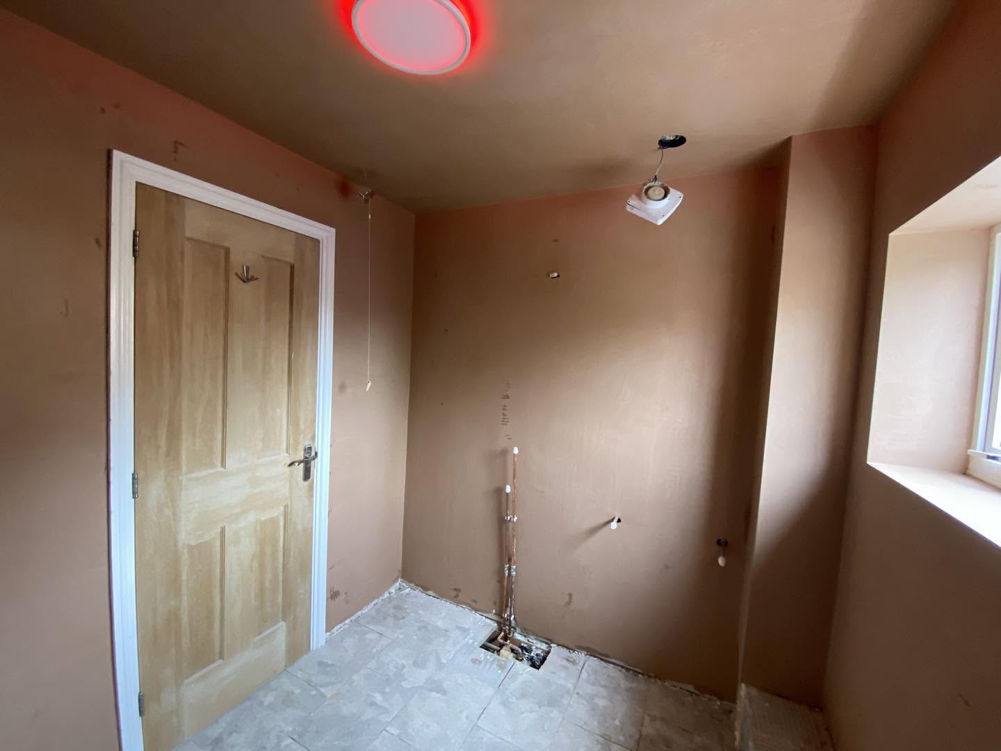 The same room fully skimmed, with an oak door