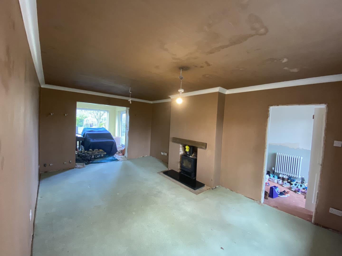 A living room after plastering, fireplace and pendant light