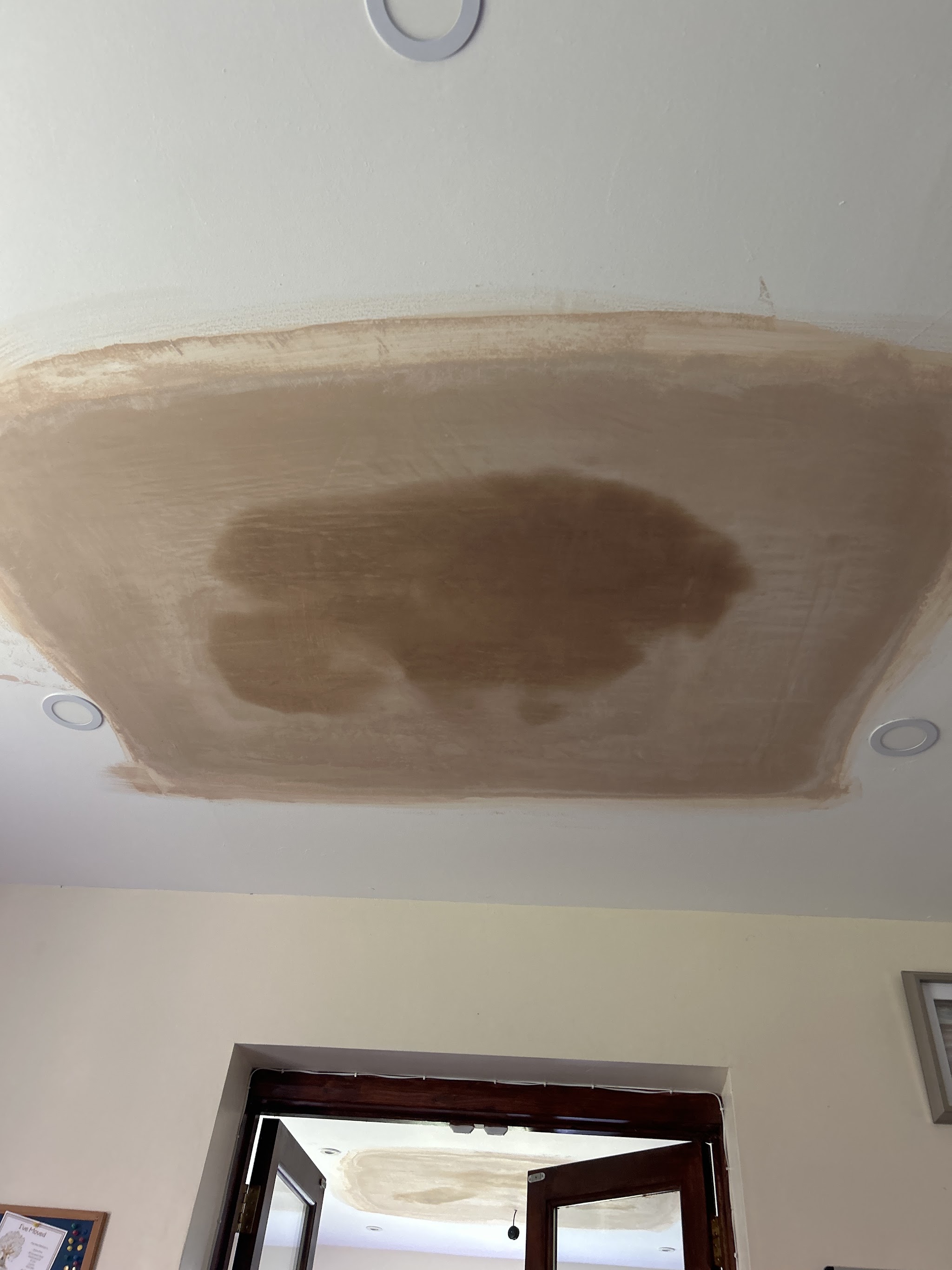 A neat rectangular ceiling patch in a pale painted room