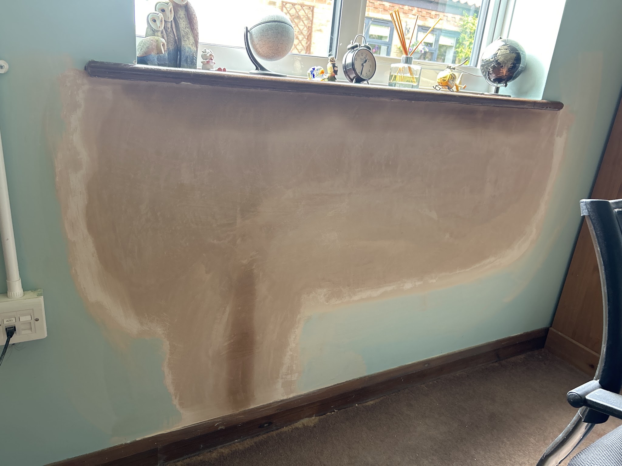 A plaster patch repair under a window sill on a painted wall