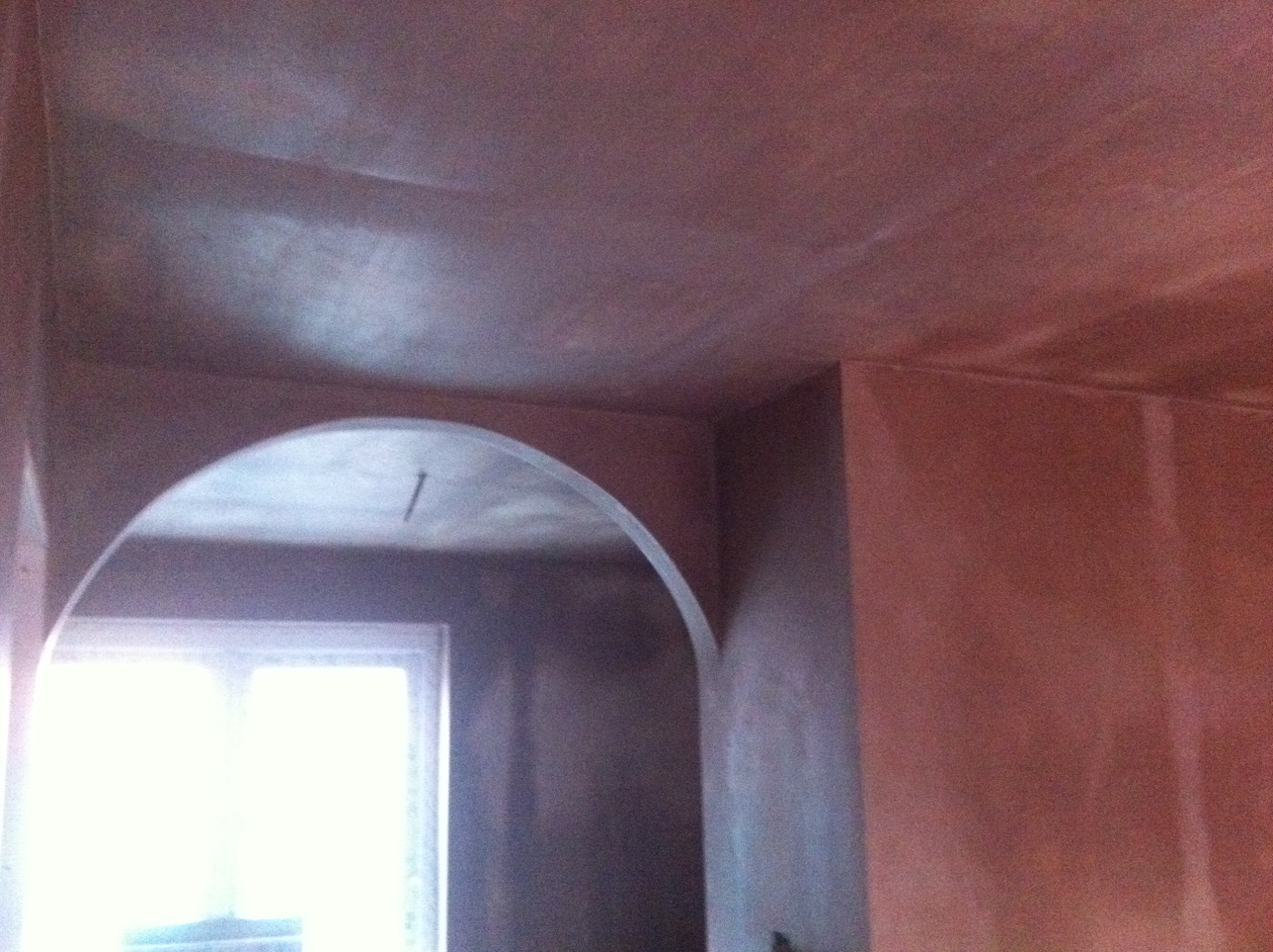 A plastered archway between two rooms