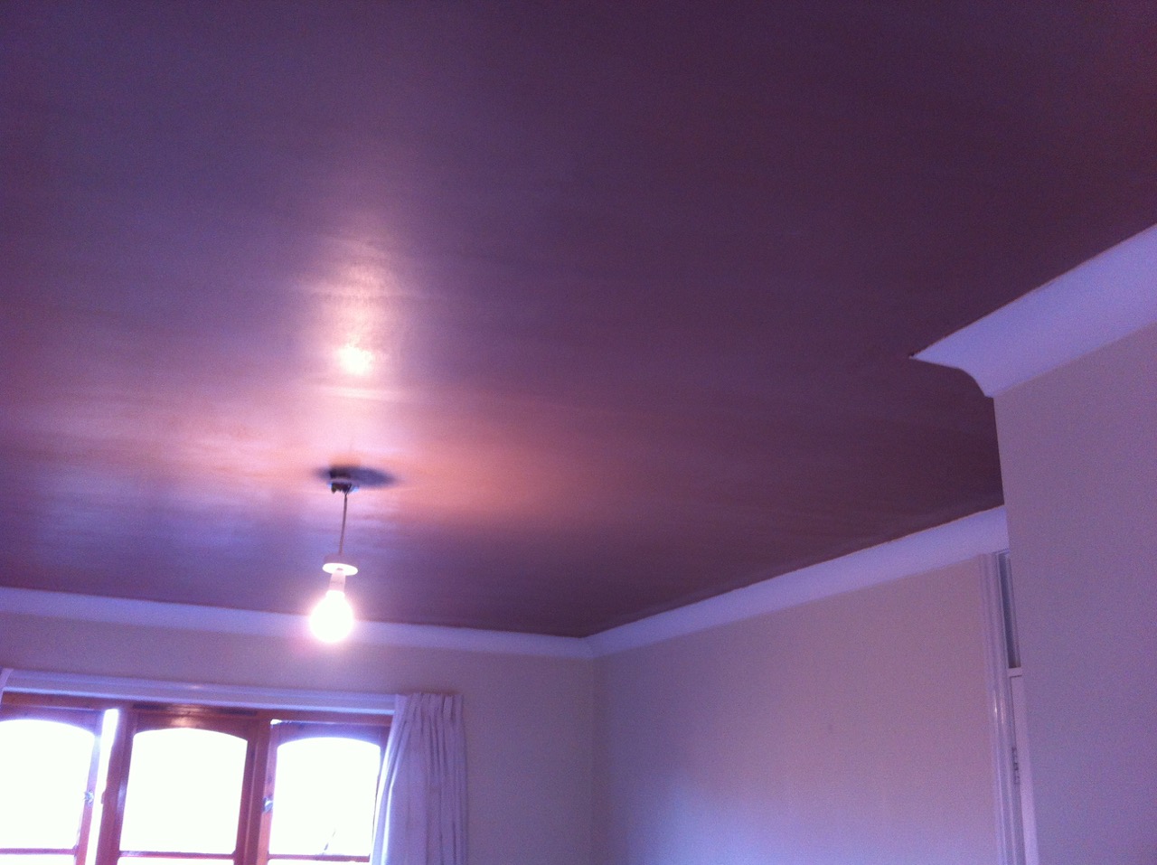 A painted ceiling meeting the walls with plaster coving