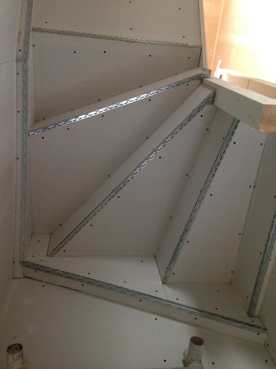 Plasterboard and steel angle beads fixed on an angled ceiling