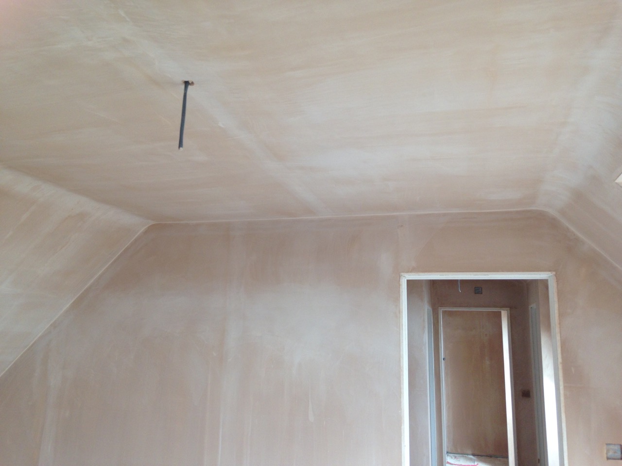 An attic room with sloped ceilings skimmed